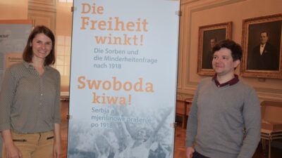 Dr. Jana Piňosová und Dr. Friedrich Pollack vom Sorbischen Institut neben der Titeltafel