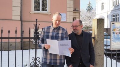 Alf-Christian Schering und Dr. Robert Lorenz (v.l.), Informatiker und Ethnologe am Sorbischen Institut, blicken in das soeben überreichte Konzept für ein Register des sorbisch-wendischen Kulturerbes © SI (2023)