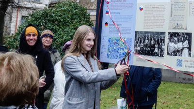 Swjatočny akt wotewrjenja wučbneje šćežki "Warnoćicy. Serbske slědy "- šulerka Warnoćanskeho gymnazija přetřiha swjedźensku seklu, kołowokoło su někotři přihladowarjo widźeć © Serbski institut / Vanessa Žurec (2024)