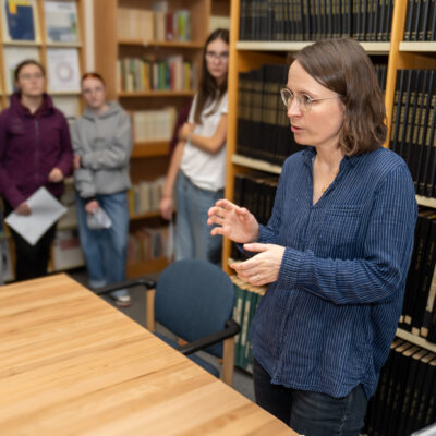 Dźeń bibliotekow 2025 - Anna Měrćinowa skići šulerjam dohlady do biblioteki © Serbske nowiny / Bojan Benić