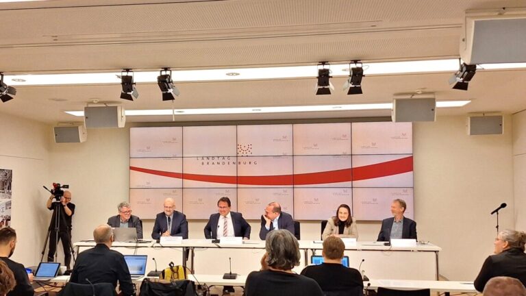 sechs Personen im Podium während einer Pressekonferenz im Landtag Brandenburg